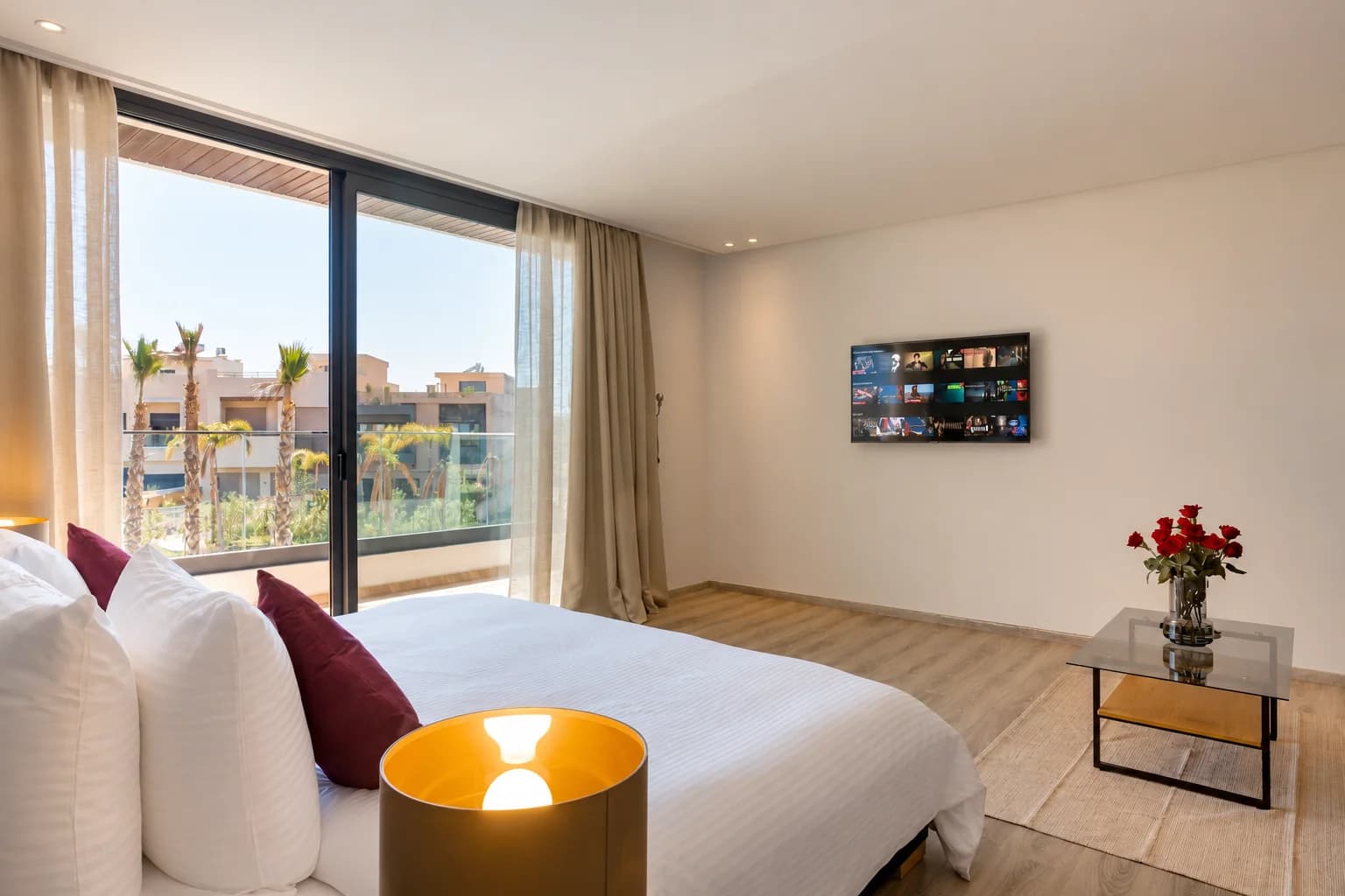 Chambre 2 de la Villa LEANA avec lit double, télévision et baie vitrée donnant sur le balcon.